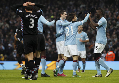 Mario Balotelli celebrates with David Silva and Adam Johnson 